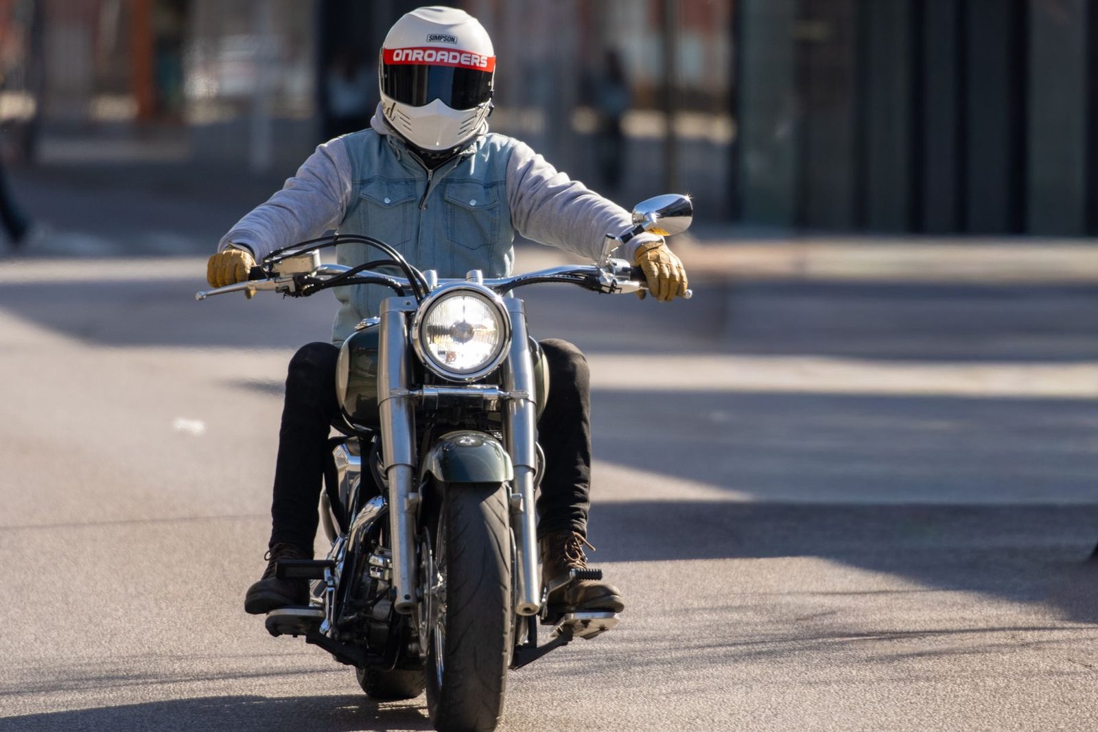 A motorcyclist wearing a helmet rides down a city street in Jönköping, Sweden.