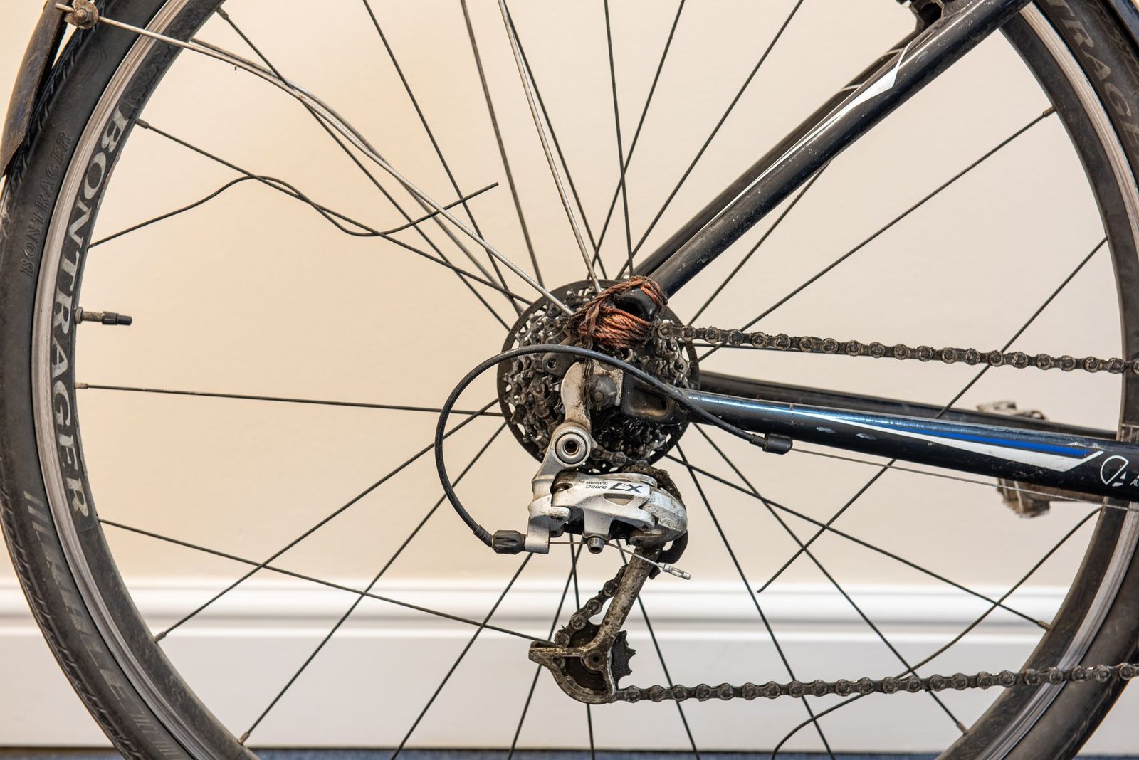 Close-up of a bicycle wheel with bent rim and broken spokes.
