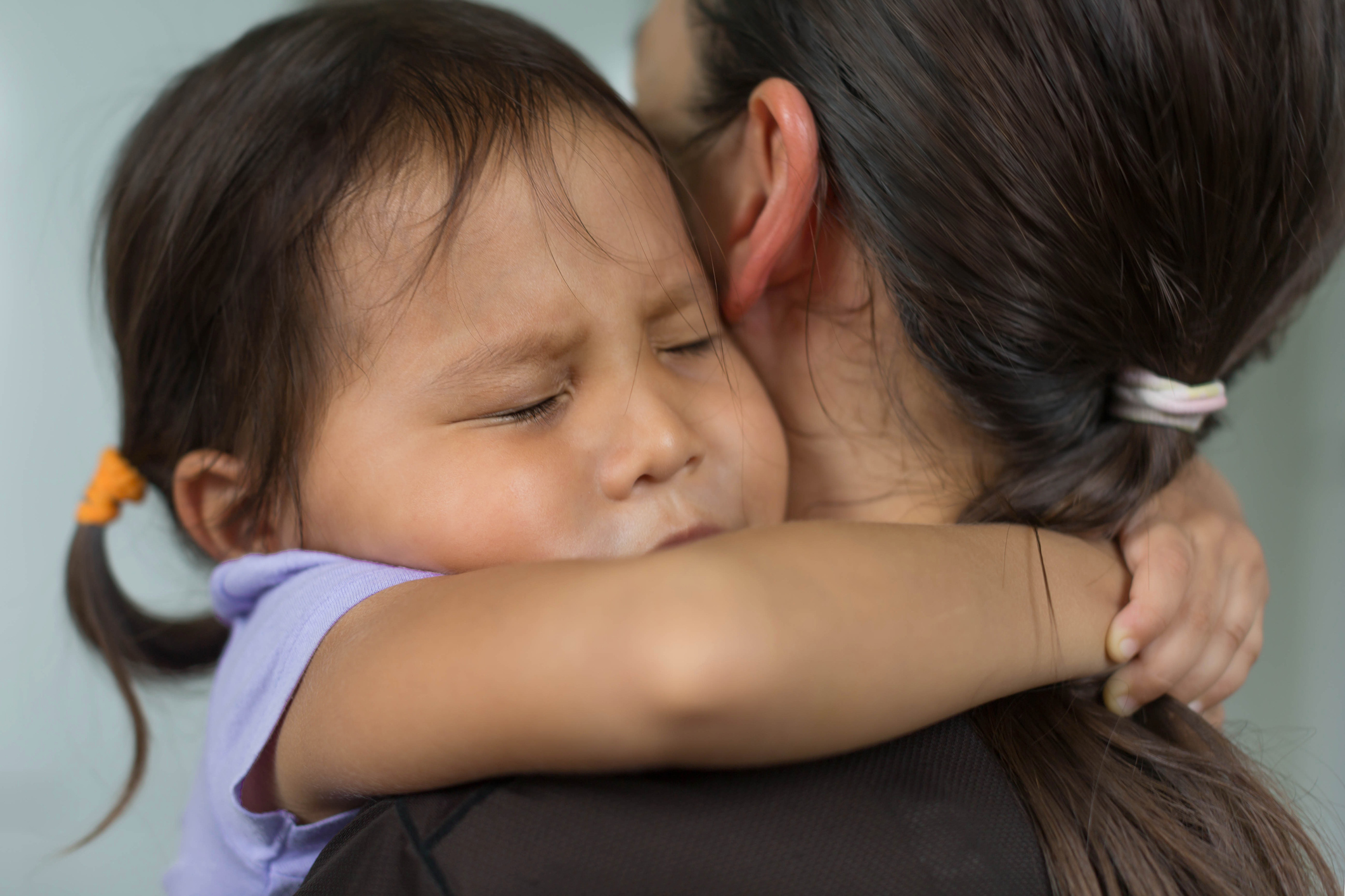 Child hugging her mother for comfort and support. Family love and affection.
