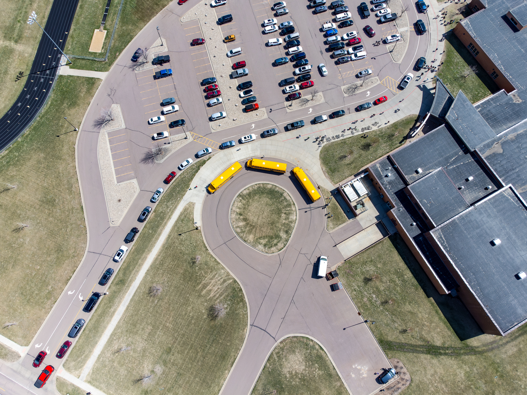 Drone overhead aerial view of a school letting out students at the end of the day.